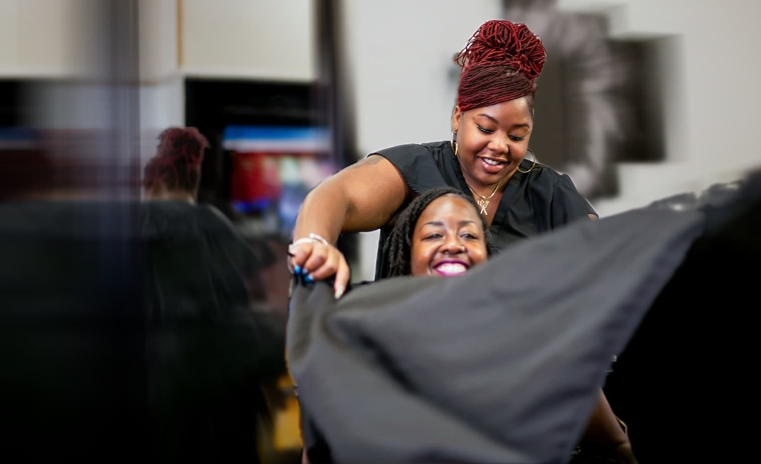 A stylist works with a client while the salon rushes past