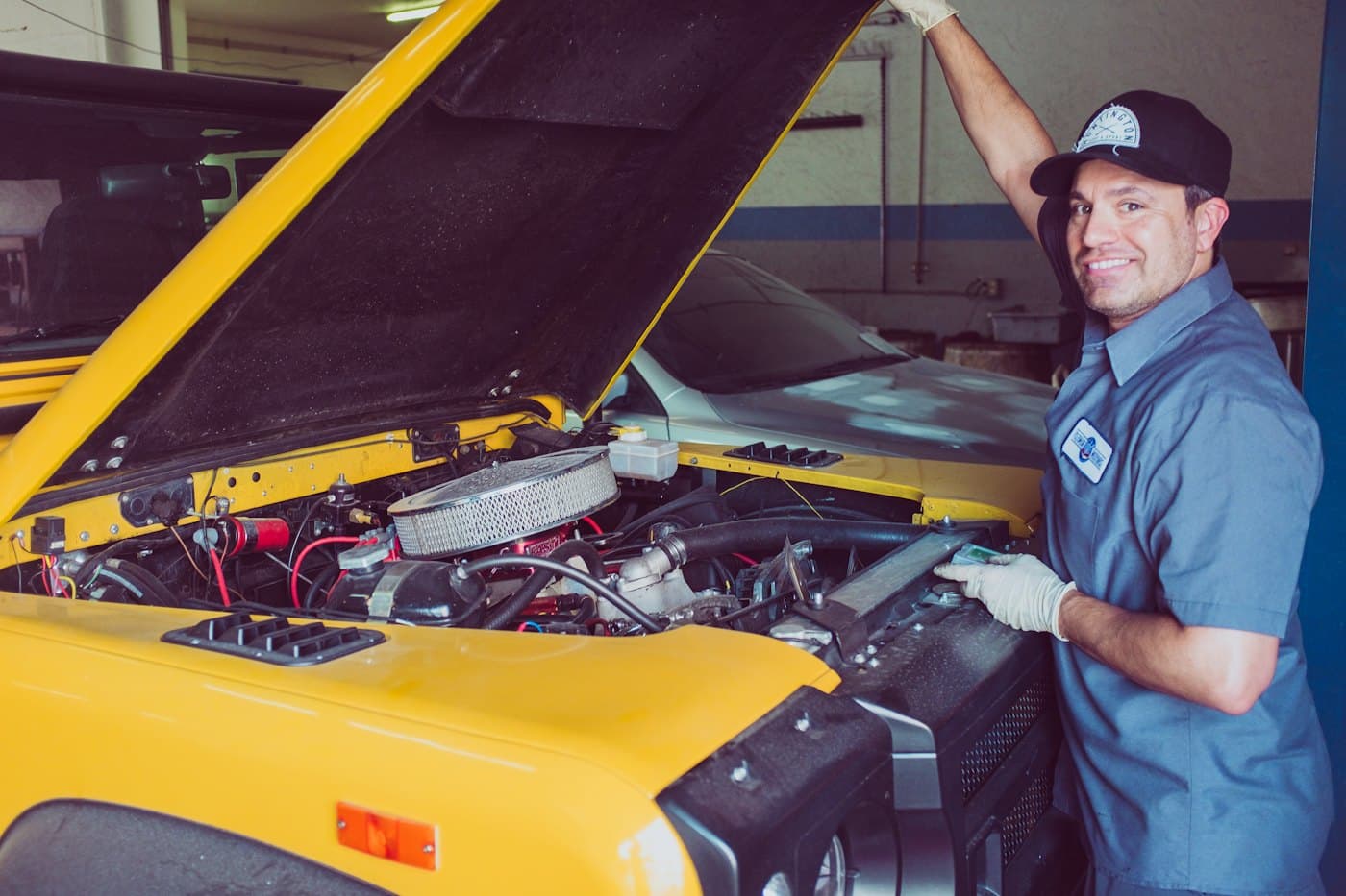 A mechanic working on a yellow car