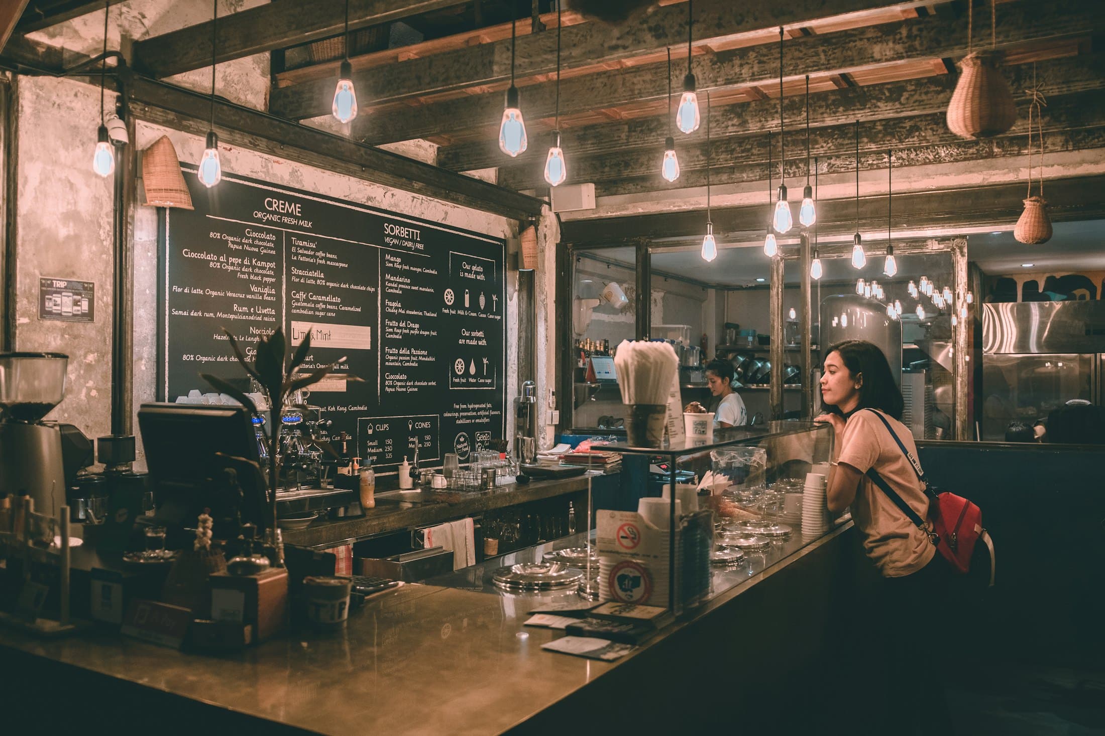 A café counter at night with a customer waiting